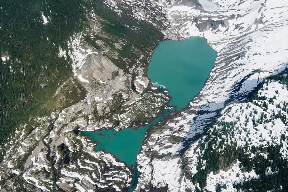 Garibaldi Lake in turquoise held between snowfields