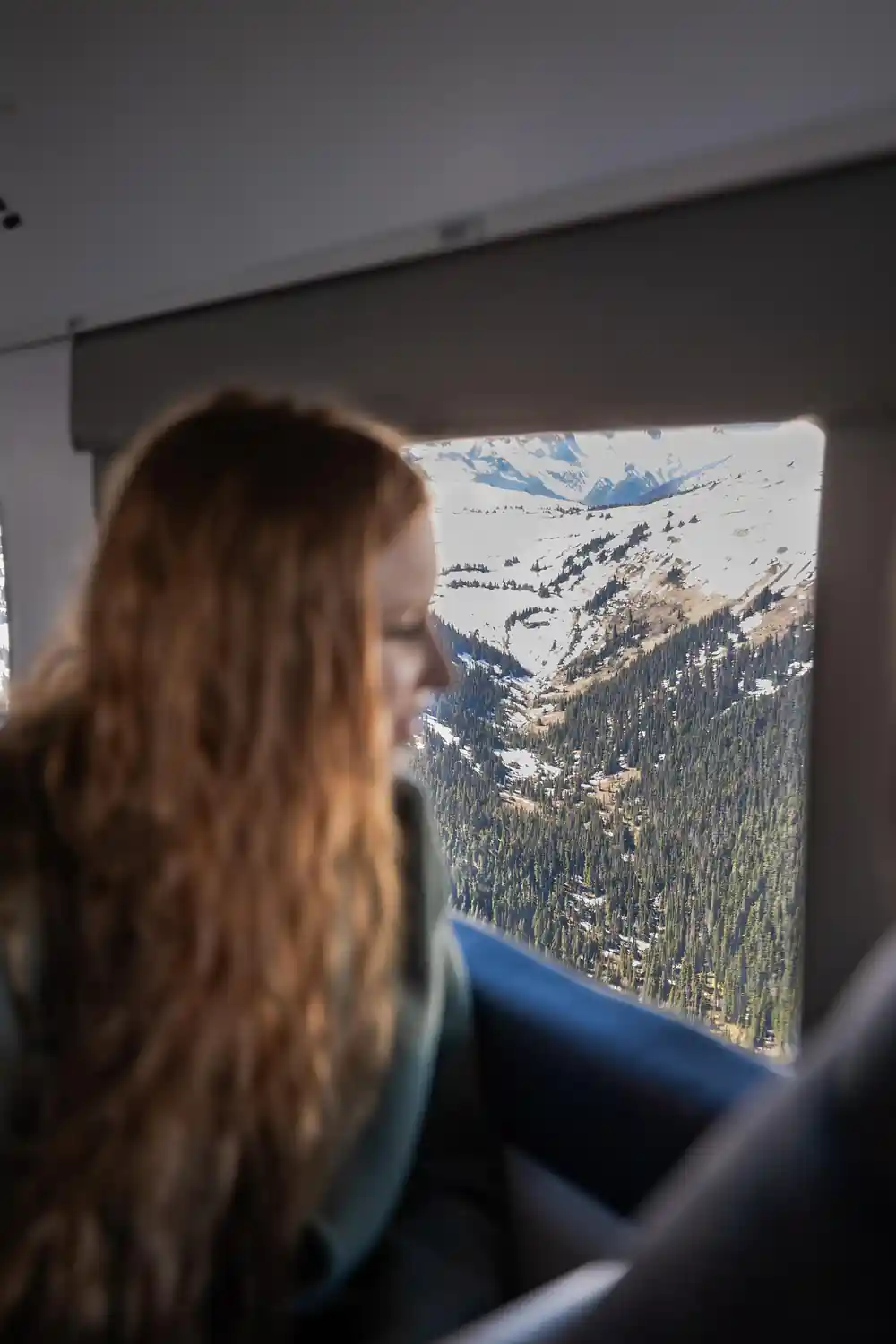 A passenger looking out at the peaks below