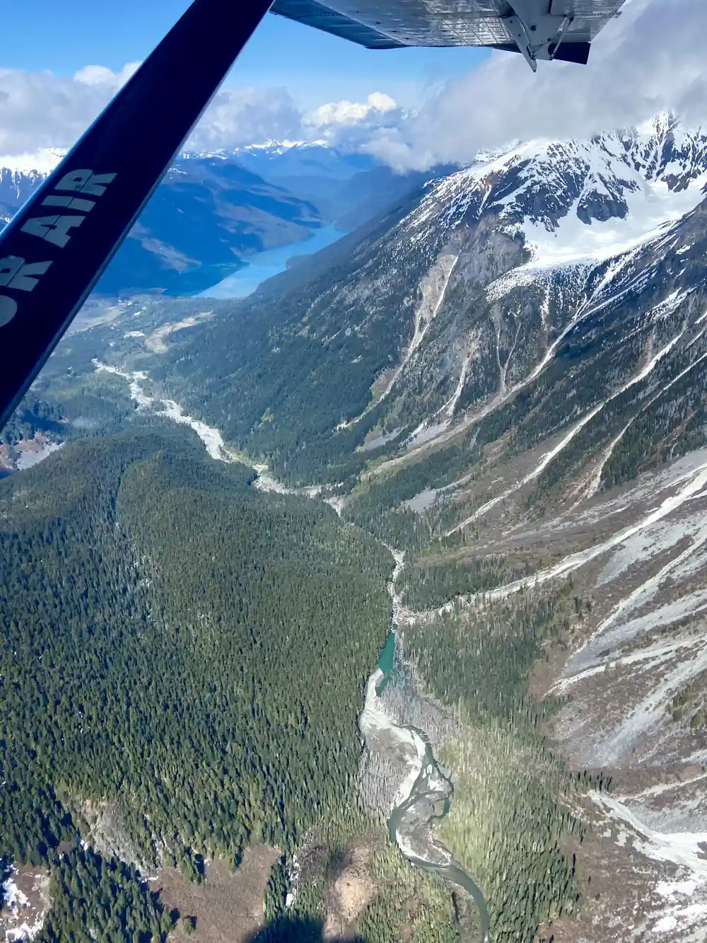 A river valley cutting between forested mountains