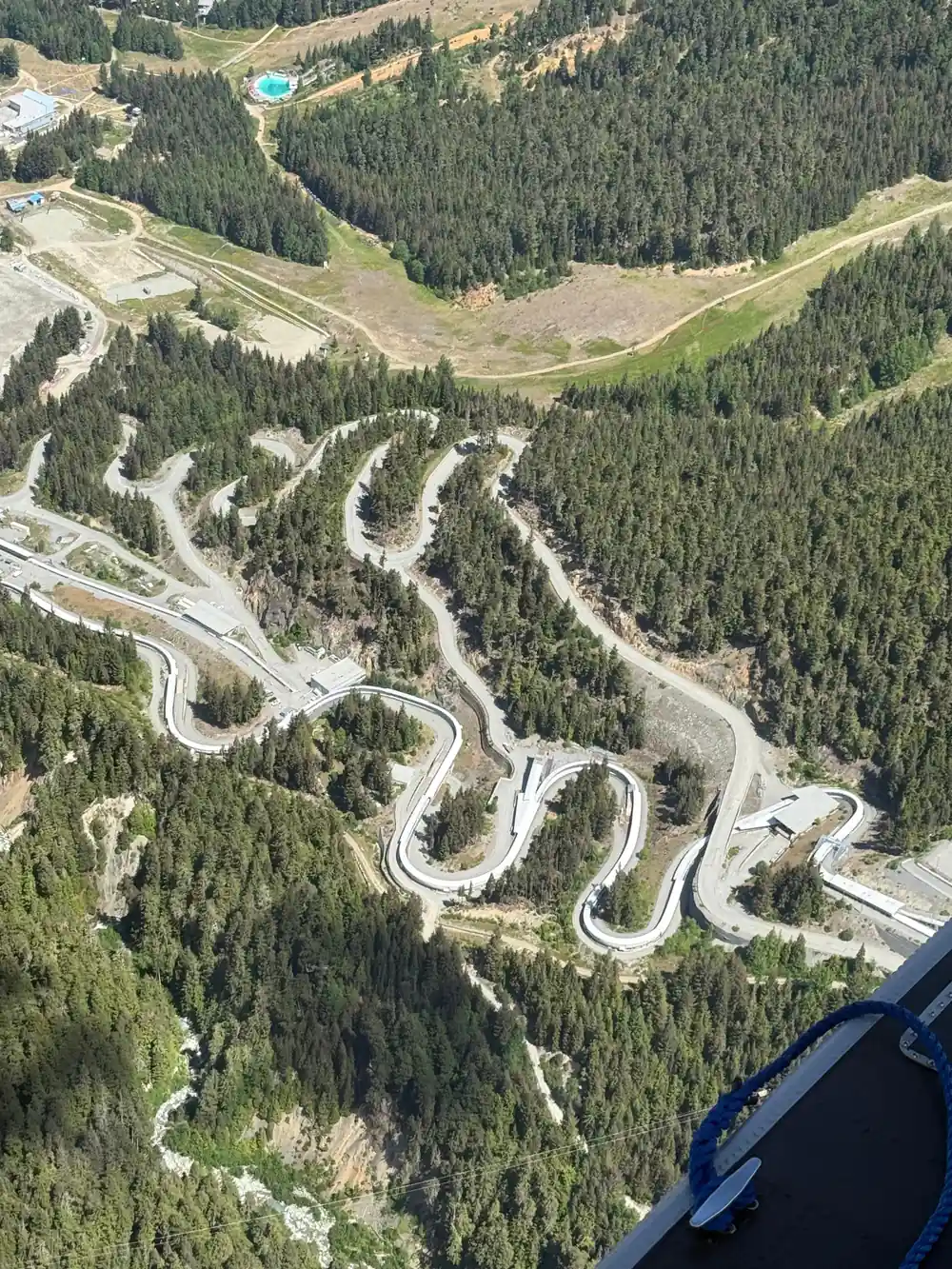 A switchback road climbing through the forest below