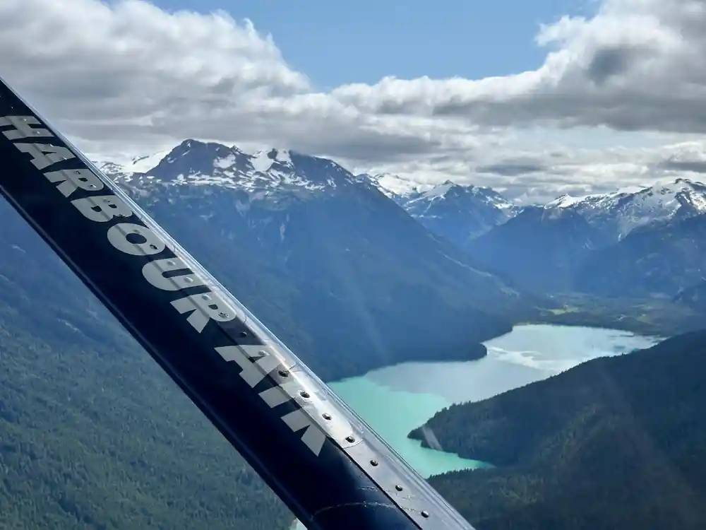 A turquoise lake far below snow-topped mountains