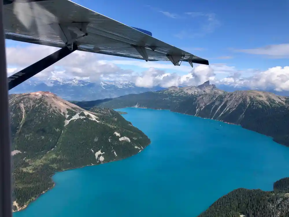 Turquoise lake seen along its length from the wing